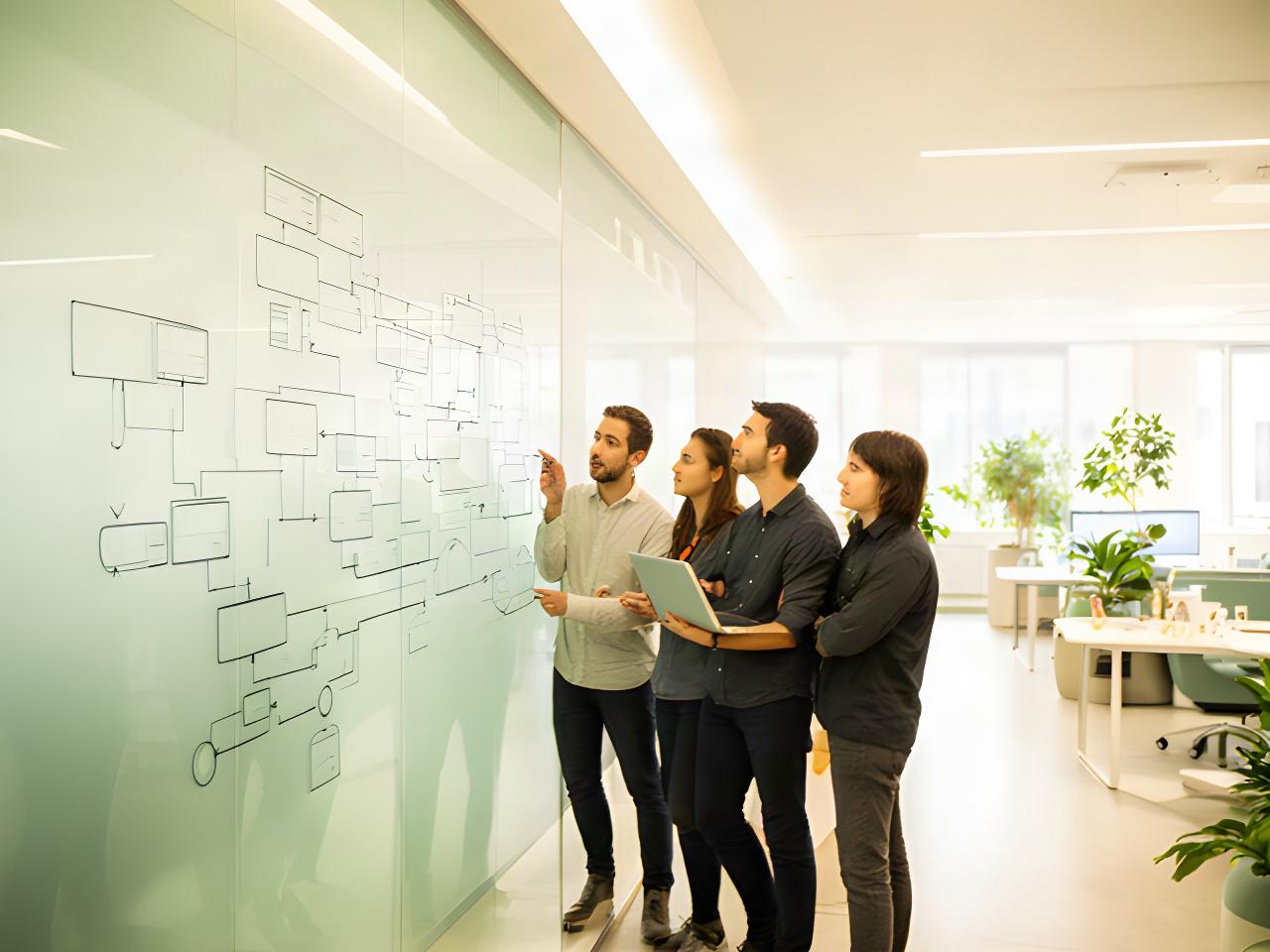 Technology specialists reviewing a cloud architecture diagram in a bright Whitehaven office