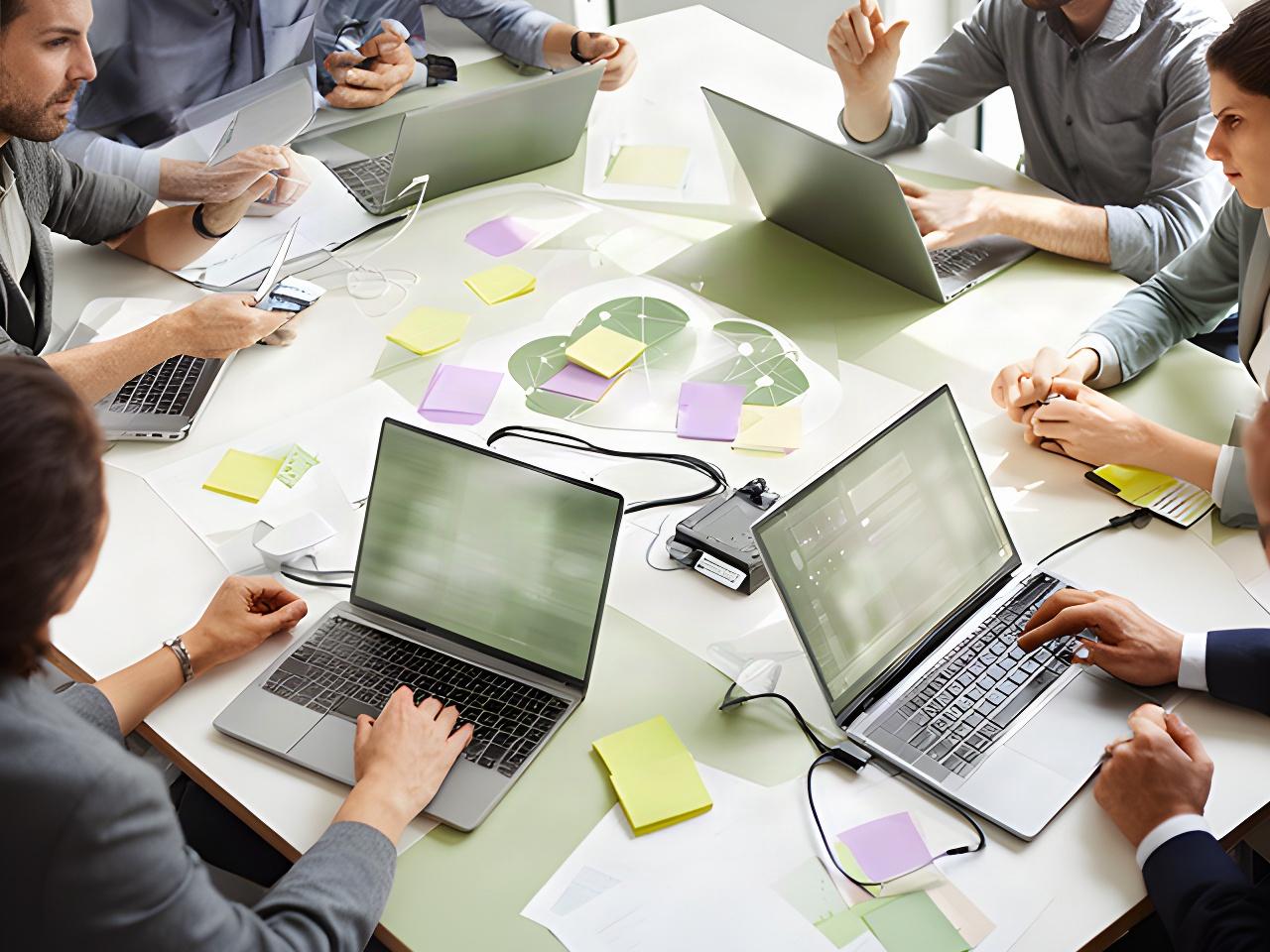 Technology specialists planning a secure cloud project around a table with notes and laptops